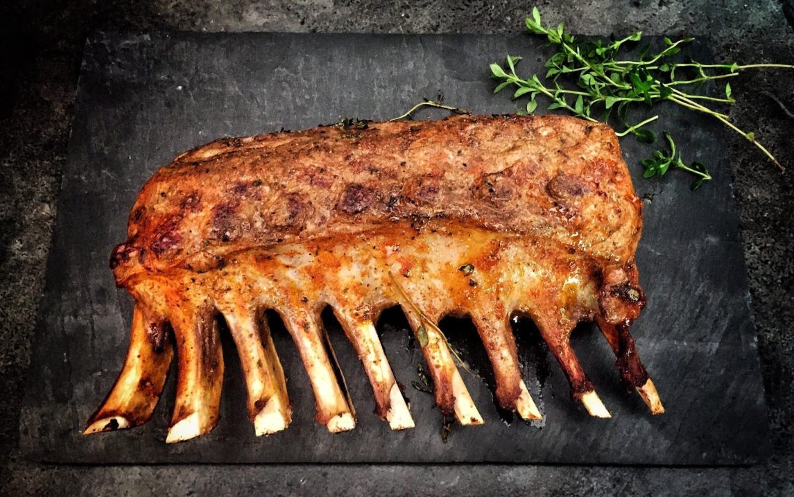 Grilled rack of lamb on slate with thyme.